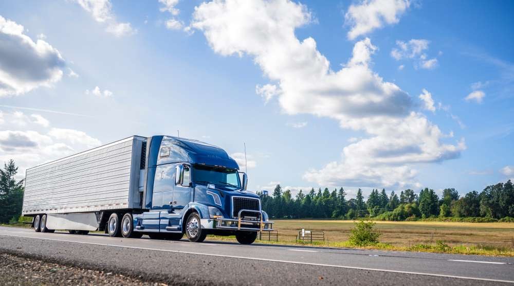 Commercial semi truck and enclosed trailer traveling on a highway
